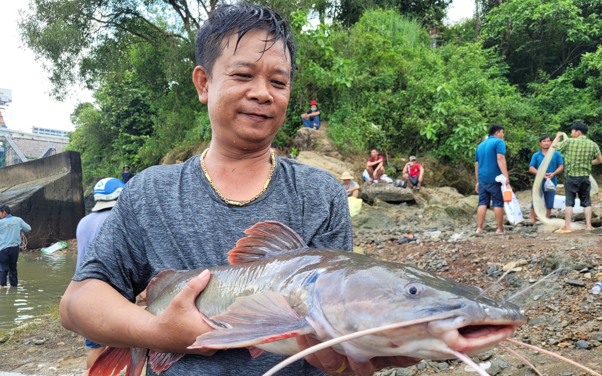 Hồ Trị An xả tr&agrave;n, người d&acirc;n n&ocirc; nức lội nước bắt c&aacute; khủng