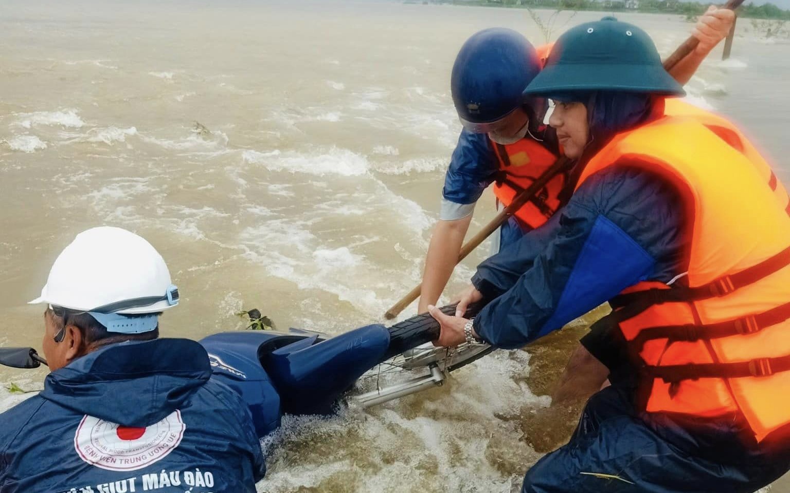 Cứu sống hai mẹ con bị nước lũ cuốn tr&ocirc;i khi đi xe m&aacute;y qua đường ngập