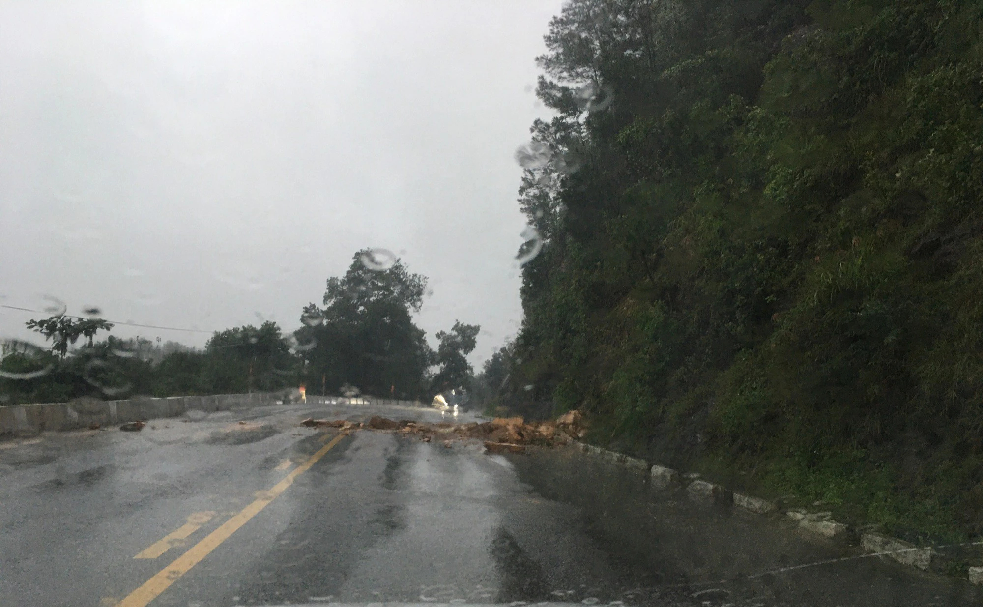 Mưa lớn, đất đ&aacute; rơi xuống QL 8A, giao th&ocirc;ng bị cản trở - Ảnh 1.