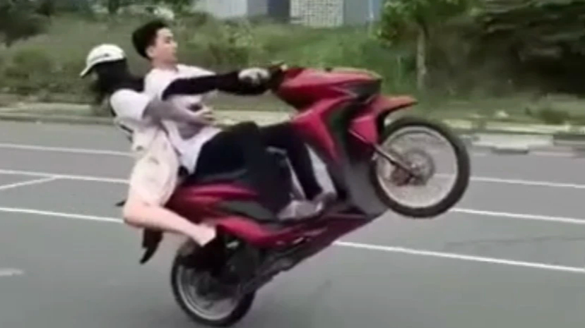 C&ocirc; g&aacute;i mặc v&aacute;y ngồi ngược chiều để bạn trai đầu trần biểu diễn bốc đầu xe - Ảnh 2.