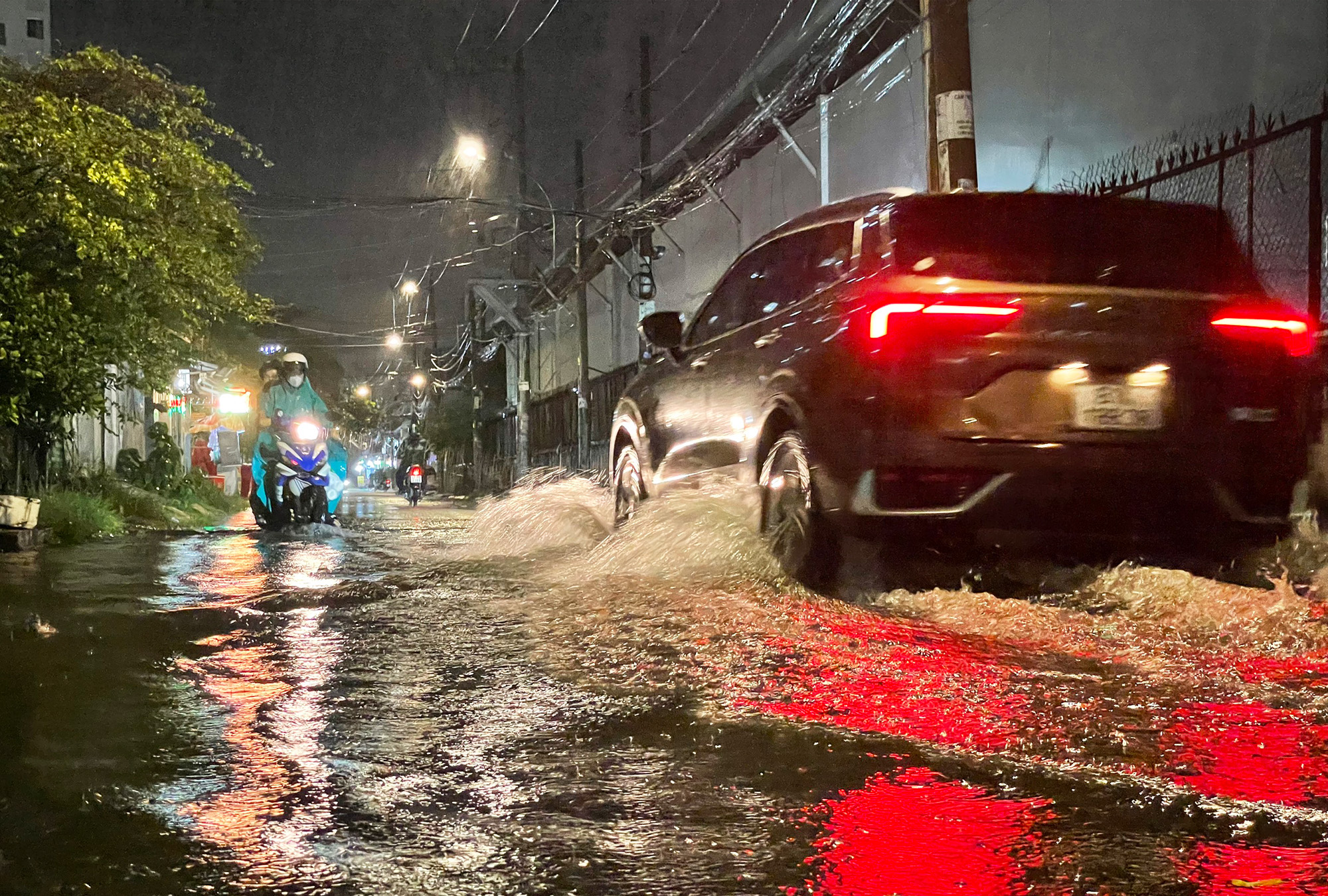 Nhiều tuyến đường tại TP.HCM ngập s&acirc;u sau trận mưa,  khiến người d&acirc;n b&igrave; b&otilde;m dắt xe giữa d&ograve;ng nước - Ảnh 1.