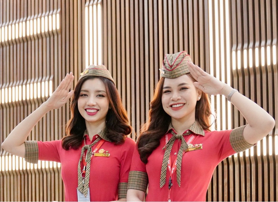 Rạng rỡ hình ảnh phi hành đoàn Vietjet tại Melbourne- Ảnh 6. Two women wearing uniforms and smiling Description automatically generated