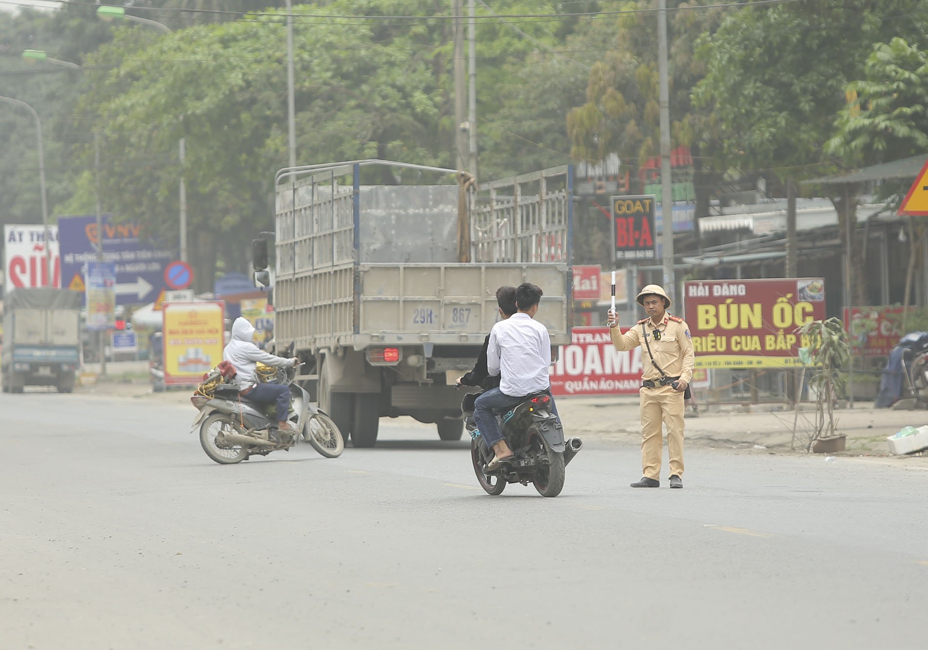 CSGT xử phạt h&agrave;ng loạt học sinh "đầu trần", ph&oacute;ng xe m&aacute;y đến trường- Ảnh 1.