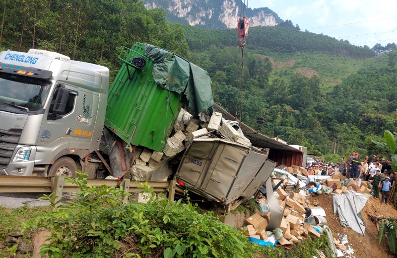 Hiện trường vụ tai nạn xe đầu k&eacute;o bị lật th&ugrave;ng h&agrave;ng, đ&egrave; l&ecirc;n xe tải nhỏ.