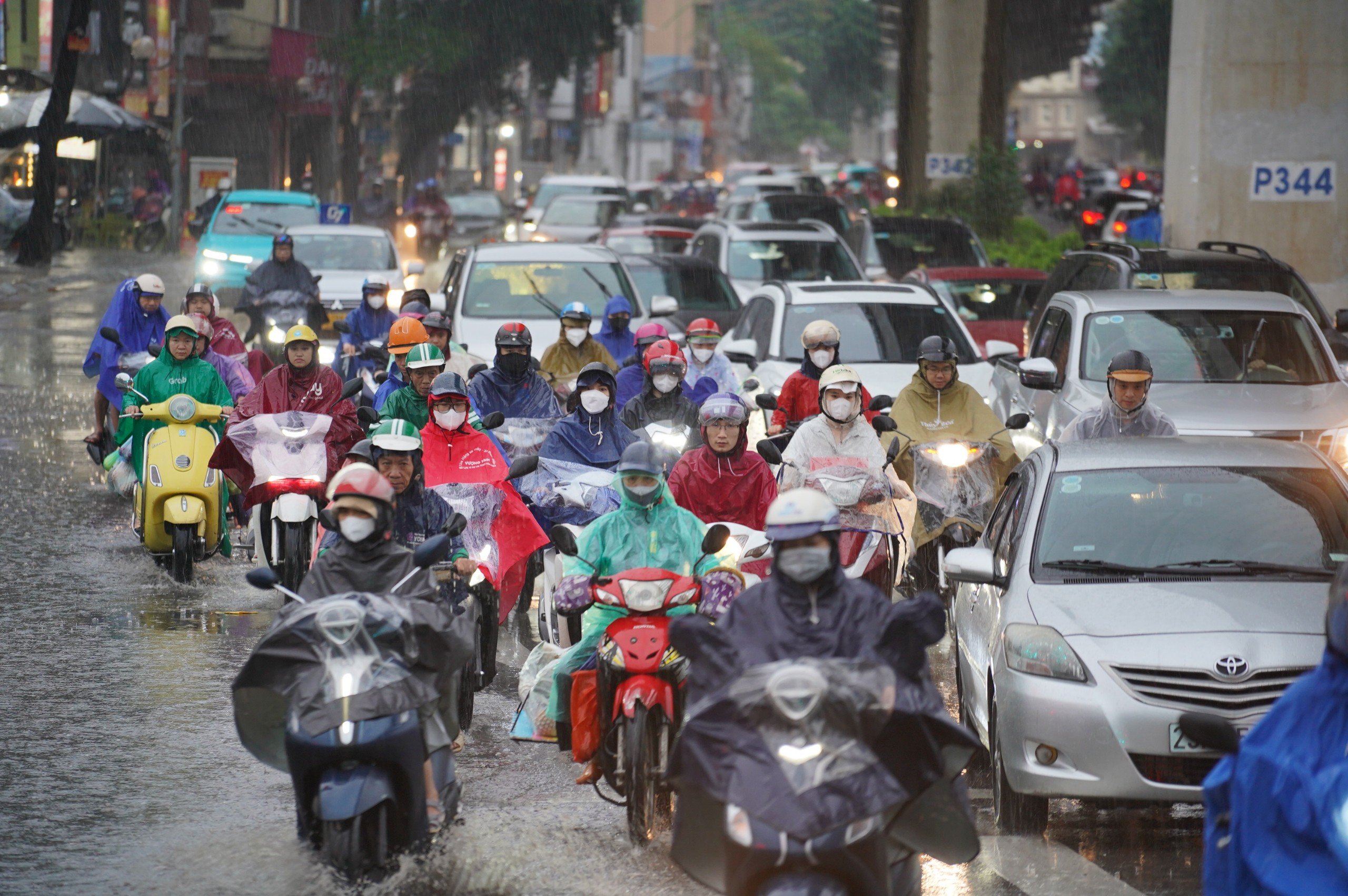 Mưa k&eacute;o d&agrave;i, người d&acirc;n H&agrave; Nội chật vật di chuyển tr&ecirc;n đường phố &ugrave;n tắc- Ảnh 1.