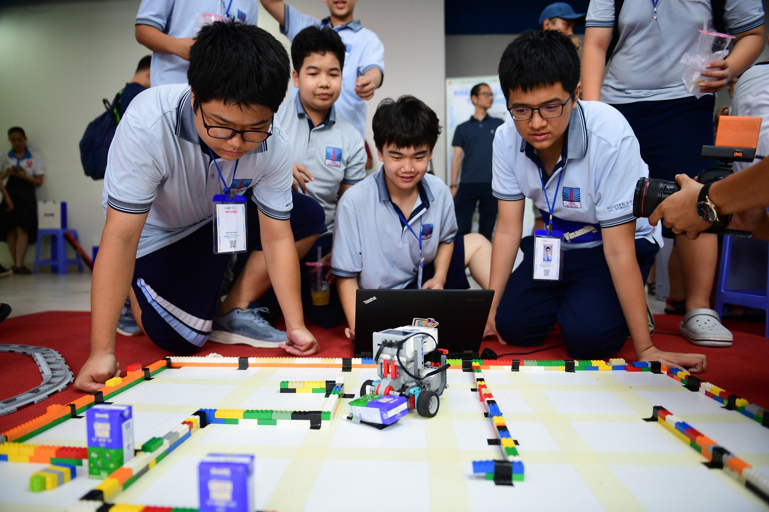 C&aacute;c bạn nhỏ h&aacute;o hứng thực hiện thử th&aacute;ch vận chuyển hộp sữa trong thời gian ngắn nhất. (Ảnh: Vi Nam)