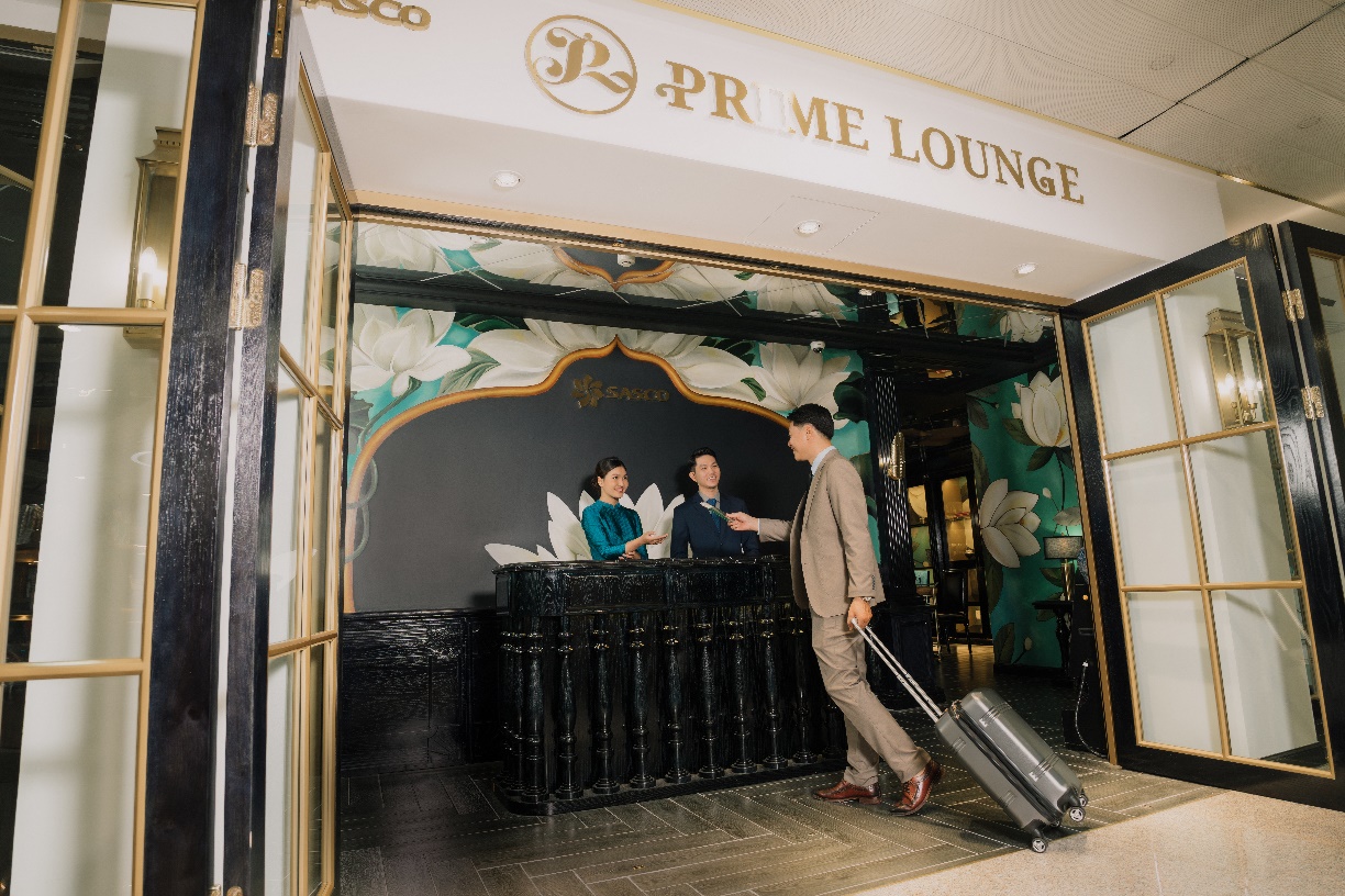 SASCO khởi động chiến dịch "Ươm mầm khát vọng xanh"- Ảnh 7. A person pulling a suitcase in front of a hotel reception Description automatically generated