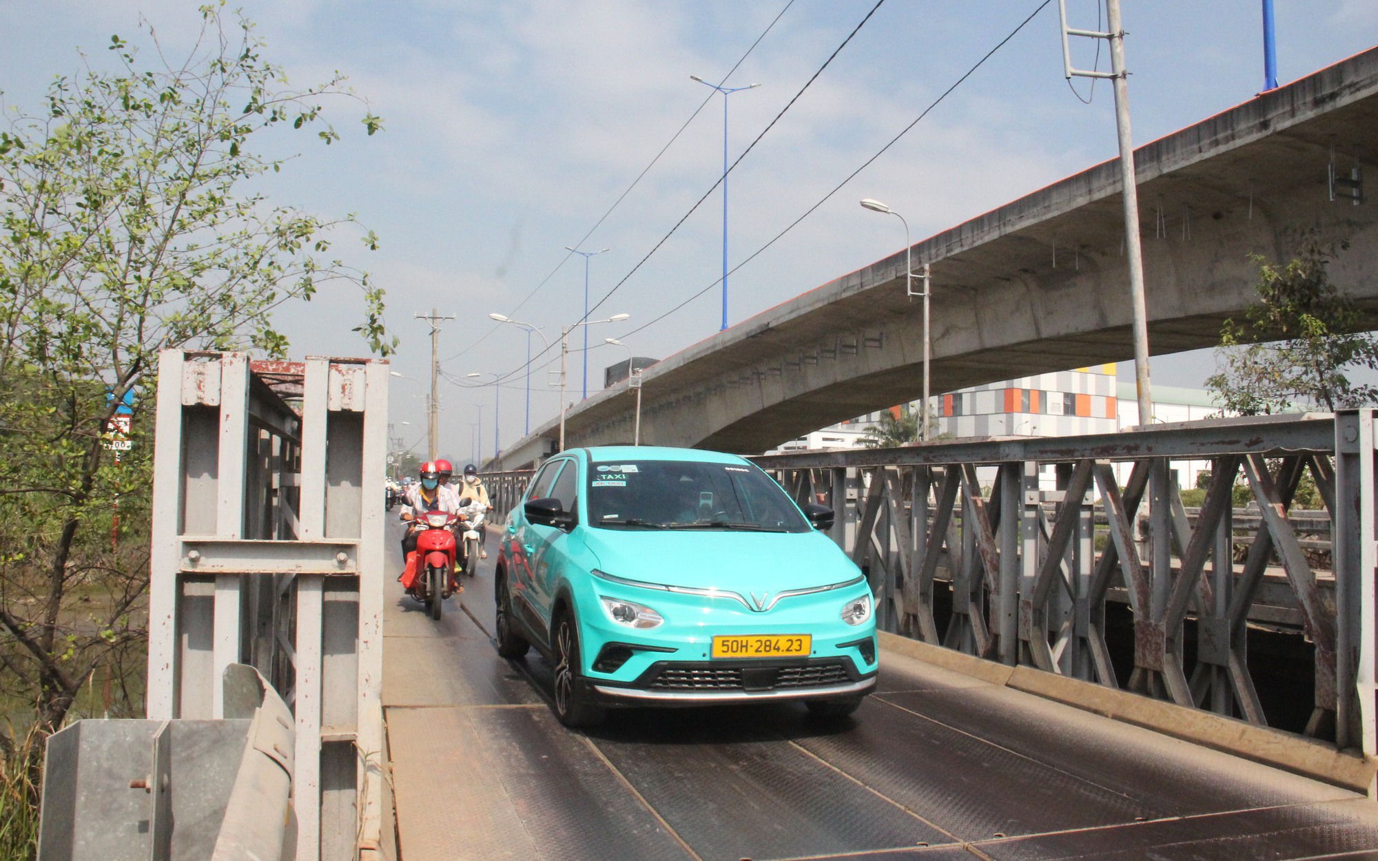 Cây cầu 700 tỷ phía Đông TP.HCM thông xe sau nhiều năm chờ đợi- Ảnh 5. Thấp thỏm qua cầu cũ, người dân ngóng ngày cầu Tăng Long mới hoàn thành