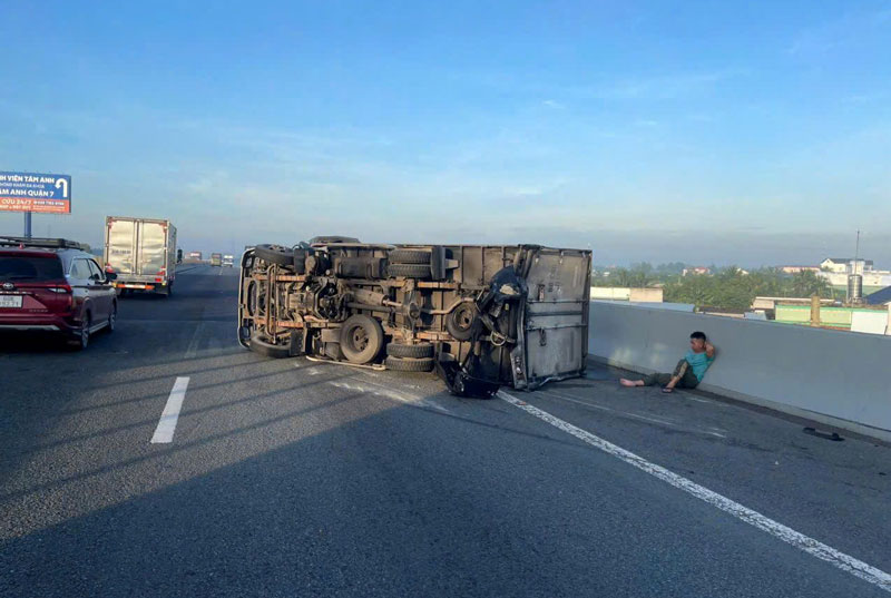 Chiếc &ocirc; t&ocirc; tải nằm lật nghi&ecirc;ng tr&ecirc;n đường cao tốc sau tai nạn.