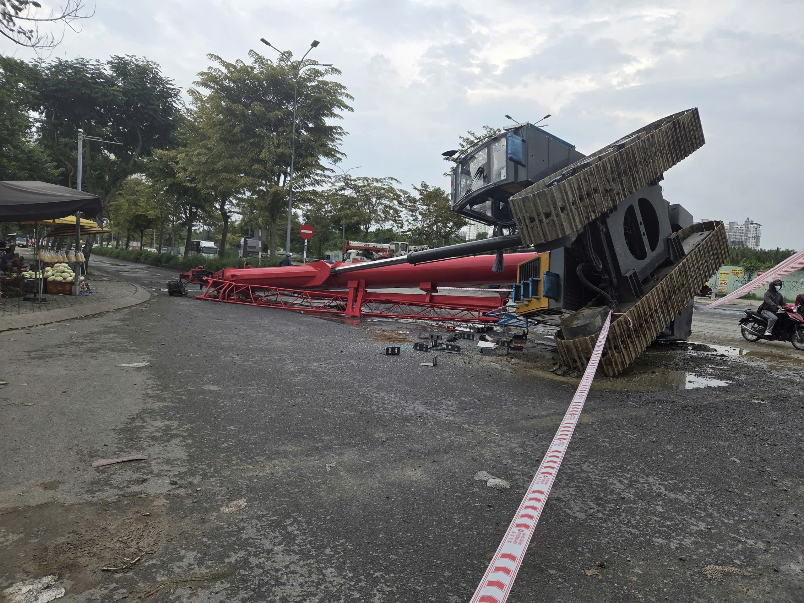 TP.HCM: Xe cẩu lật khỏi đầu k&eacute;o nằm chắn ngang đường, một người trọng thương- Ảnh 1.