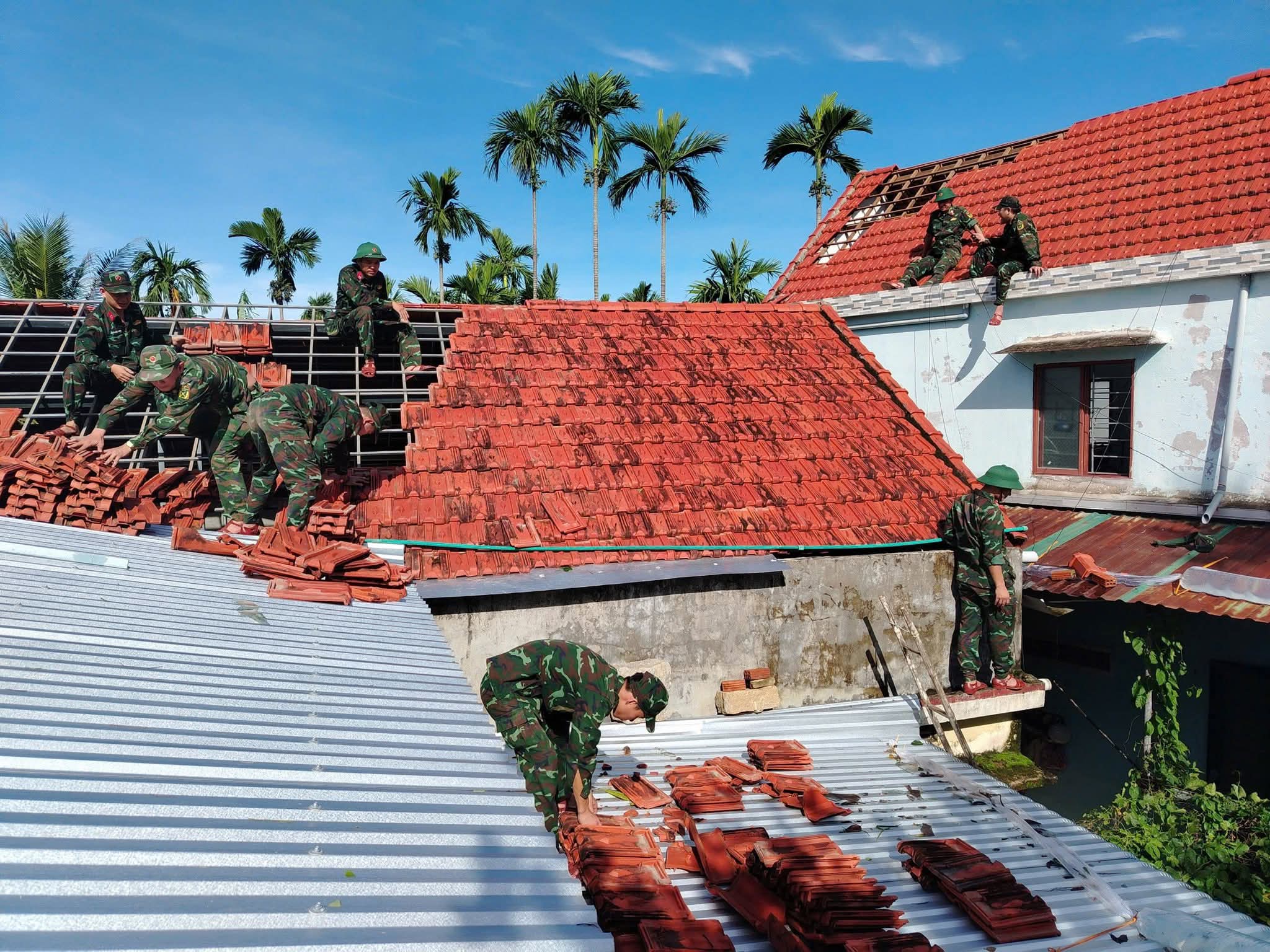 Bộ đội, c&ocirc;ng an gi&uacute;p người d&acirc;n Quảng Ng&atilde;i lợp m&aacute;i nh&agrave;, dọn c&acirc;y đổ, th&ocirc;ng đường sau b&atilde;o- Ảnh 1.