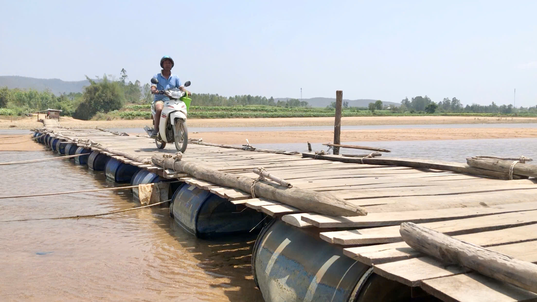 Chờ cầu xây mới, người dân lấy thùng phi ghép gỗ làm cầu tạm vượt sông Ba- Ảnh 2. Chờ cầu xây mới, người dân lấy thùng phi ghép gỗ làm cầu tạm vượt sông Ba- Ảnh 2.