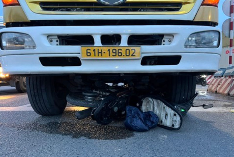 Chiếc xe máy bị cuốn dưới gầm ô tô tải - Ảnh: Thống Nhất. Chiếc xe máy bị cuốn dưới gầm ô tô tải - Ảnh: Thống Nhất.