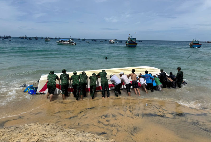 Lực lượng chức năng cứu hộ, đưa ca n&ocirc; v&agrave;o bờ.