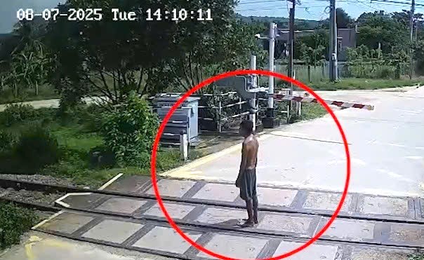 Người đ&agrave;n &ocirc;ng vượt g&aacute;c chắn, đứng giữa đường sắt khi t&agrave;u hỏa đang lao tới- Ảnh 1.