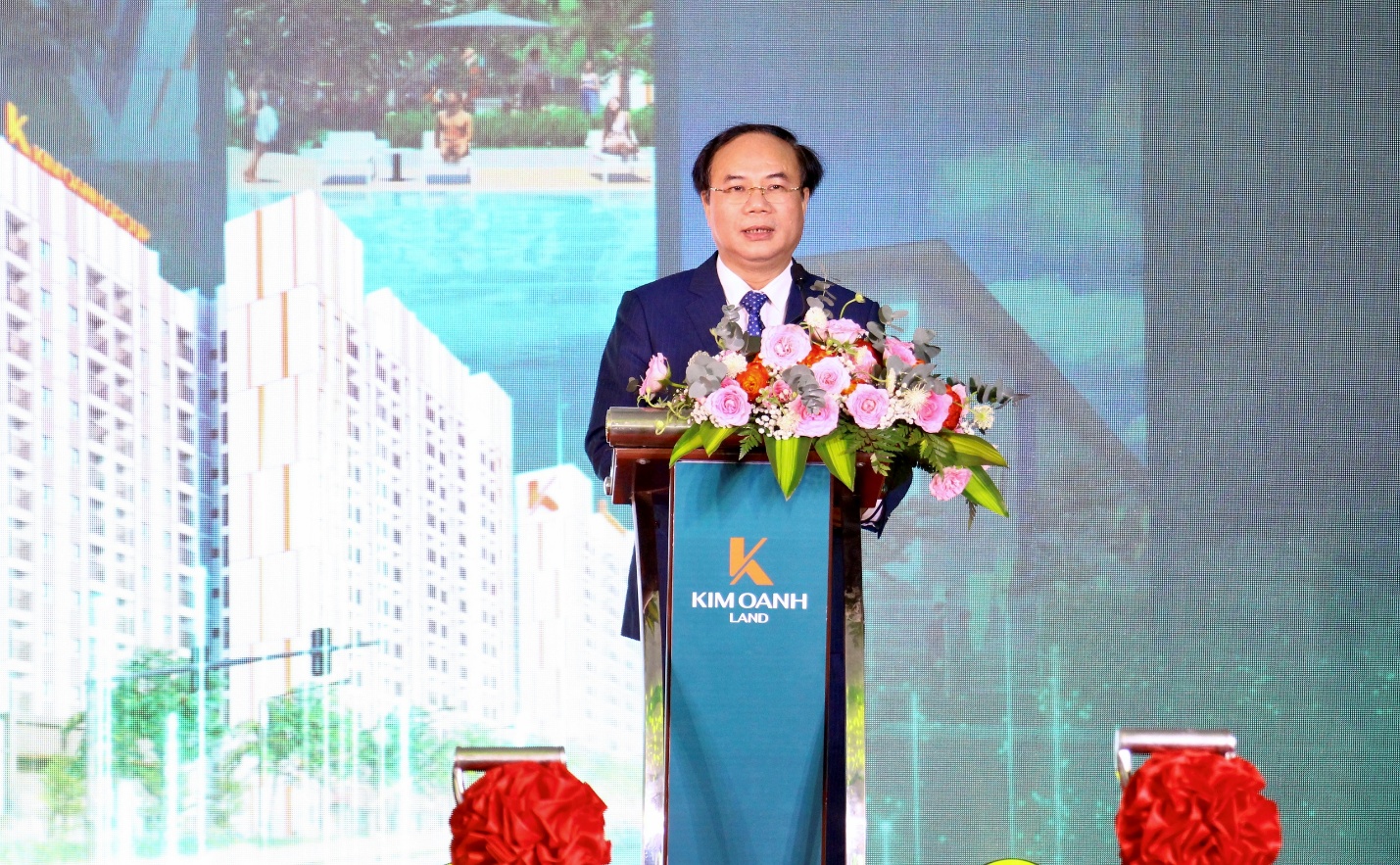 Dong Nai contributes to the goal of 1 million social housing units by 2030- Ảnh 1. A person standing at a podium with flowers AI-generated content may be incorrect.