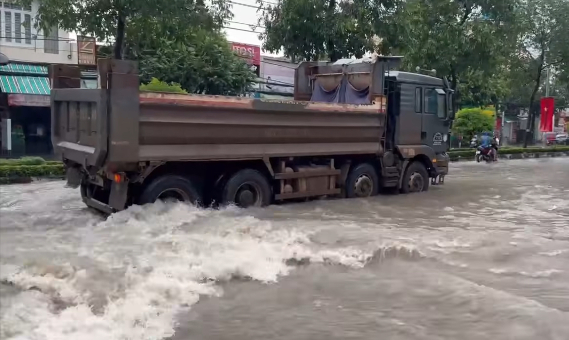 Đồng Nai: Mưa lớn, nước tr&ecirc;n đường như th&aacute;c, xe ben chắn s&oacute;ng cho người đi xe m&aacute;y- Ảnh 1.