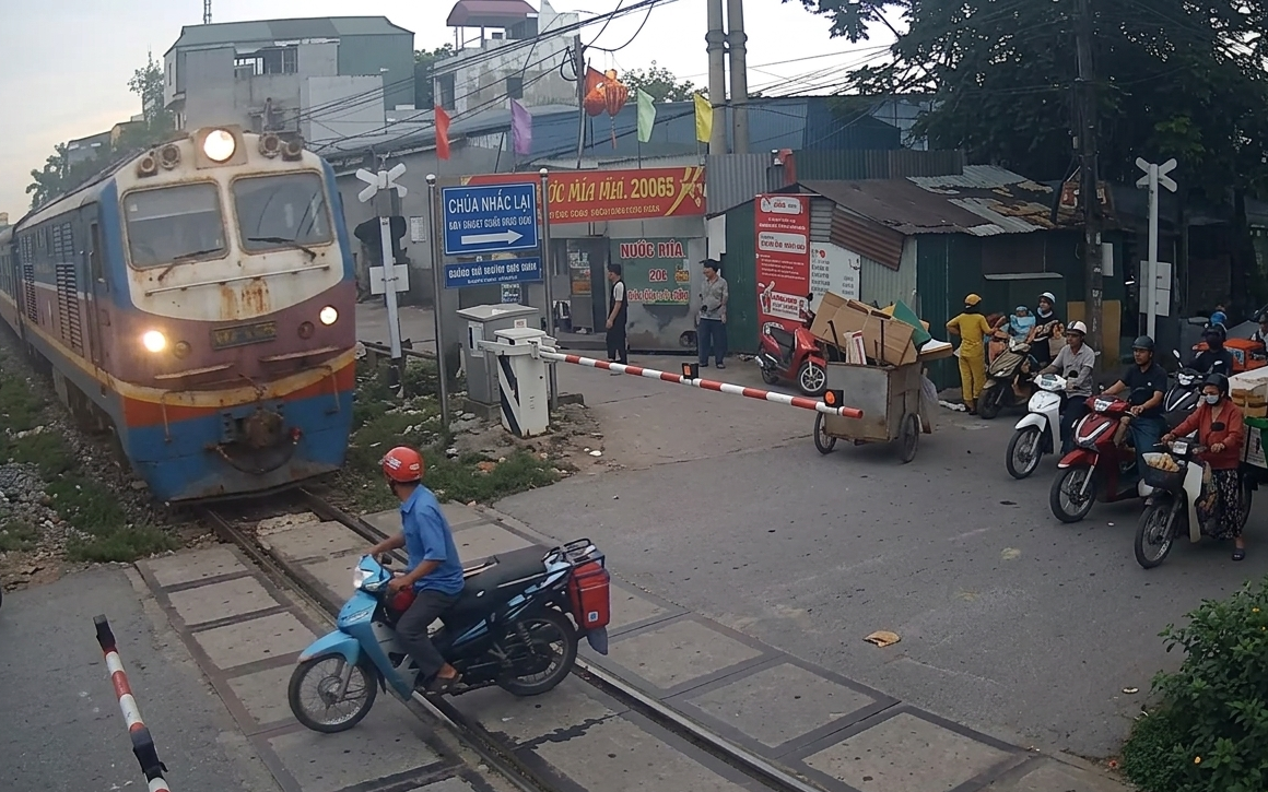 Người đ&agrave;n &ocirc;ng đi xe m&aacute;y va chạm t&agrave;u hỏa khi nghe điện thoại, vượt r&agrave;o chắn đường sắt