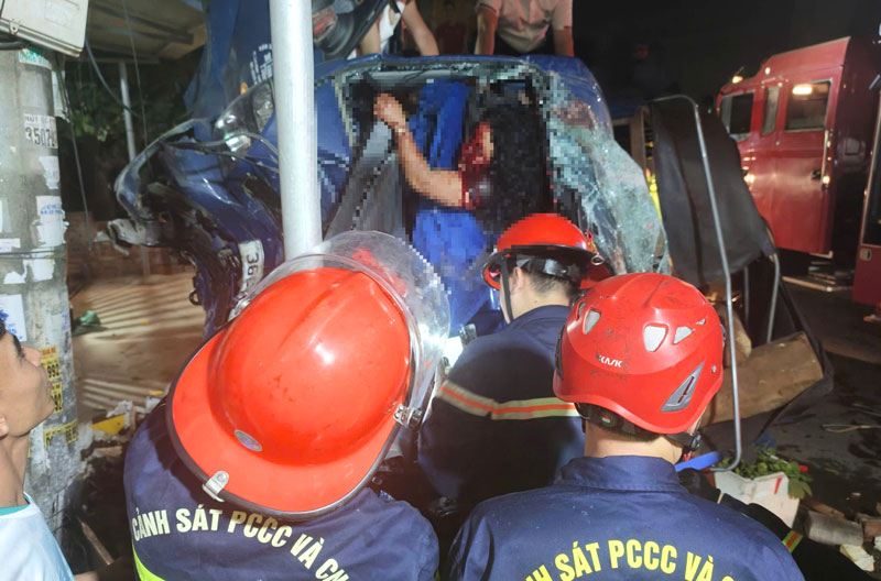 Lực lượng chức năng nhanh ch&oacute;ng cứu hai người mắc kẹt trong cabin xe tải.