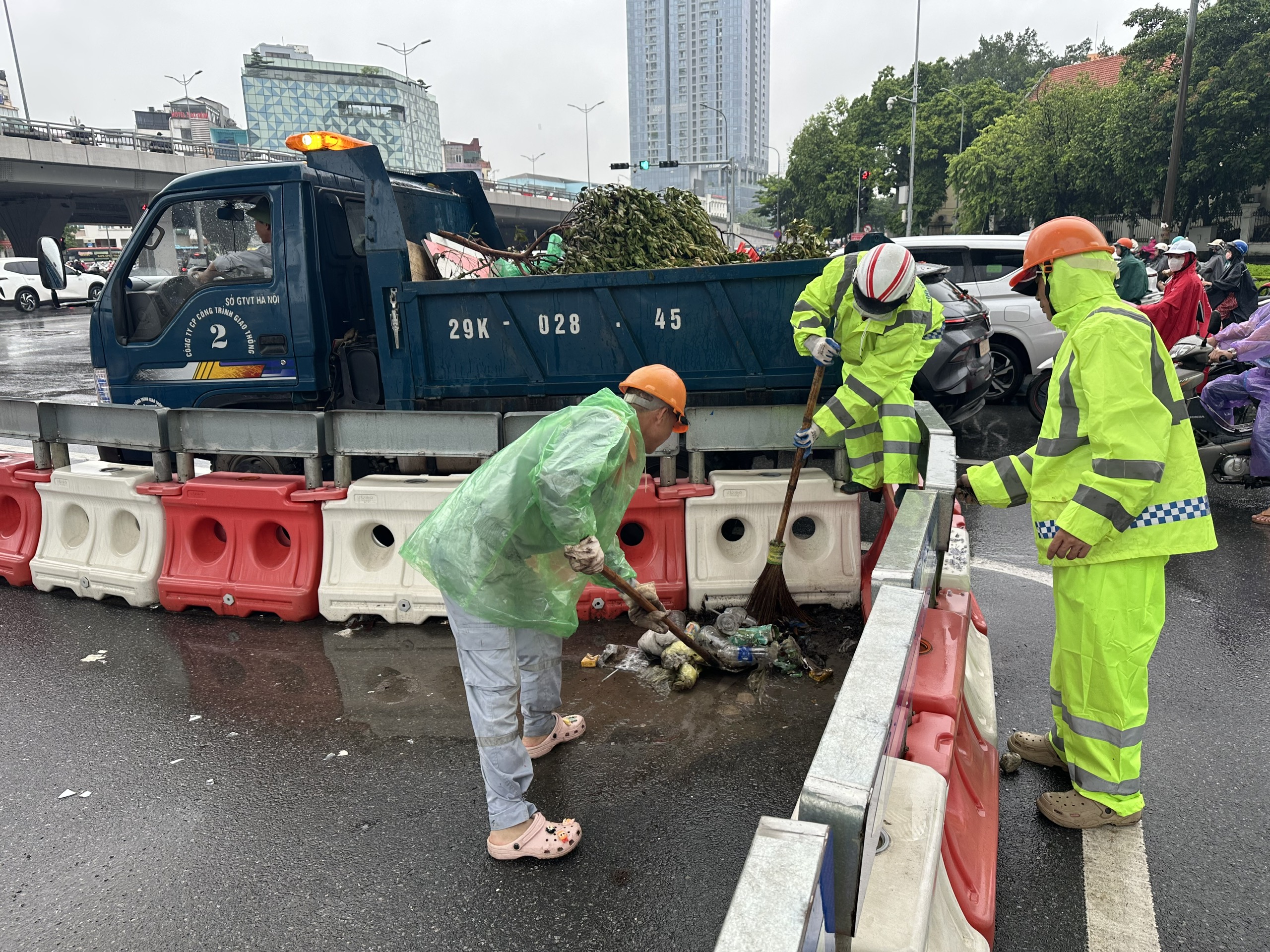 Ch&ugrave;m ảnh: C&ocirc;ng nh&acirc;n tất bật "đội mưa" chỉnh trang đ&ocirc; thị, giao th&ocirc;ng trước kỳ nghỉ lễ 2/9 - Ảnh 8.