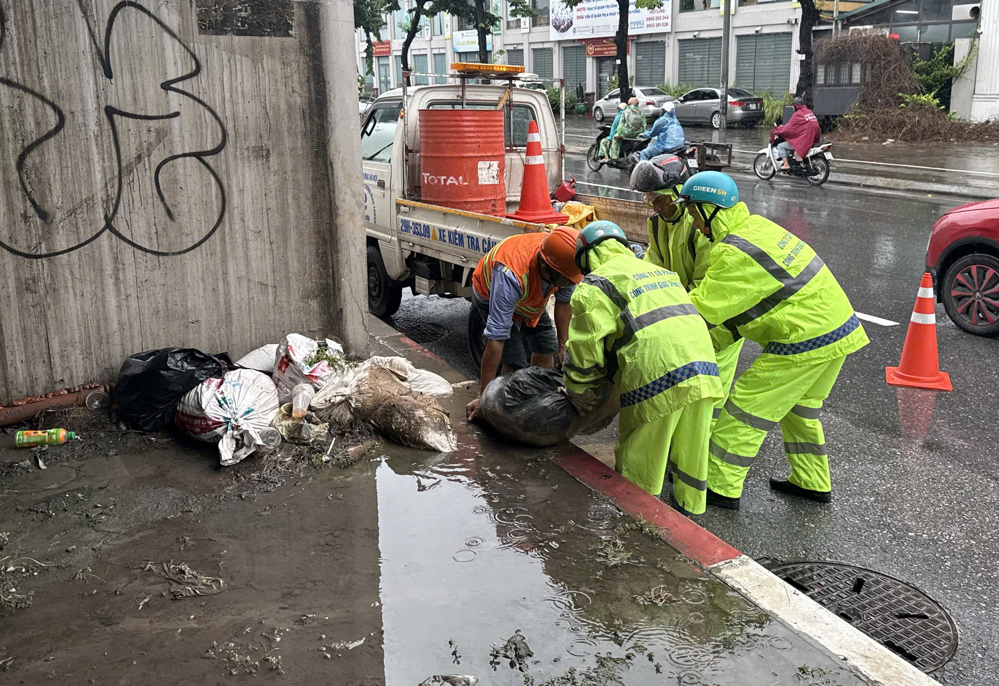 Ch&ugrave;m ảnh: C&ocirc;ng nh&acirc;n tất bật "đội mưa" chỉnh trang đ&ocirc; thị, giao th&ocirc;ng trước kỳ nghỉ lễ 2/9 - Ảnh 9.