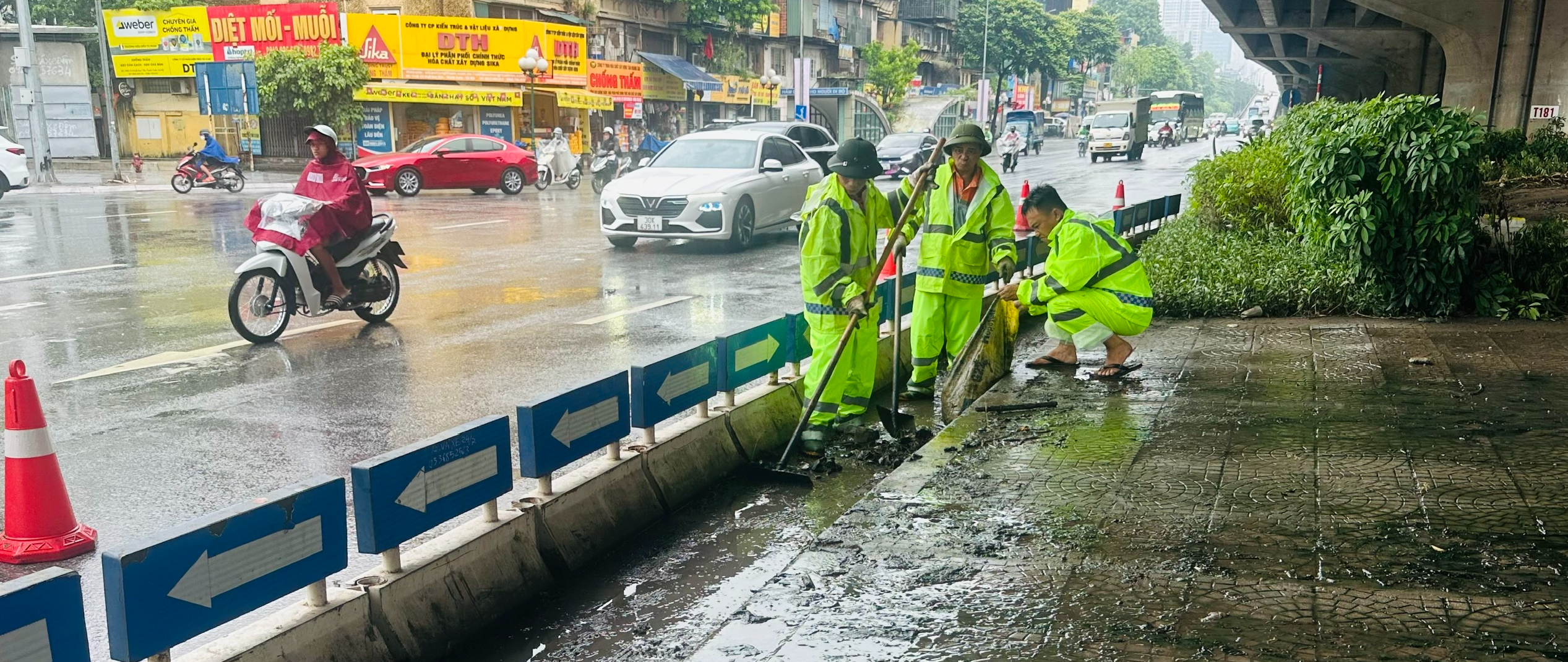 Ch&ugrave;m ảnh: C&ocirc;ng nh&acirc;n tất bật "đội mưa" chỉnh trang đ&ocirc; thị, giao th&ocirc;ng trước kỳ nghỉ lễ 2/9 - Ảnh 3.