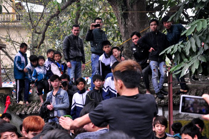 Do s&acirc;n đ&igrave;nh qu&aacute; đ&ocirc;ng, lũ trẻ con phải tr&egrave;o l&ecirc;n bờ tường để theo d&otilde;i kh&ocirc;ng kh&iacute; n&aacute;o nhiệt của giằng b&ocirc;ng