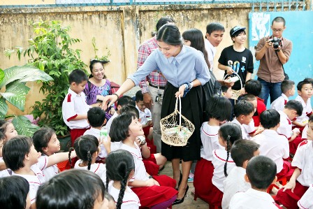 Hoa hậu Trương Thị May hướng dẫn c&aacute;c em học sinh gấp hộp sữa v&agrave; thu hồi để l&agrave;m tấm lợp sinh th&aacute;i