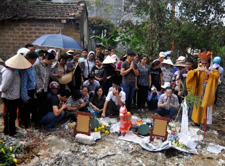 Khu vực hiện trường xảy ra vụ tai nạn một số gia đ&igrave;nh chỉ kịp dải tạm tờ b&aacute;o để đặt di ảnh v&agrave; bộ qu&acirc;n phục để thắp hương.