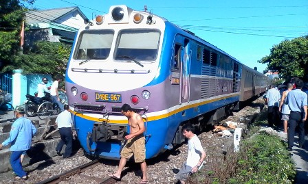 C&aacute;c nh&acirc;n vi&ecirc;n, lực lượng chức năng tr&ecirc;n t&agrave;u v&agrave; người d&acirc;n địa phương t&igrave;m c&aacute;ch đưa người phụ nữ ra khỏi gầm t&agrave;u v&agrave; đưa l&ecirc;n xe chở đến Bệnh viện cấp cứu