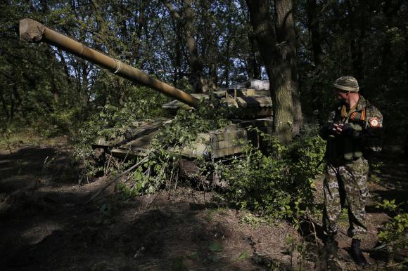 Người biểu t&igrave;nh chống ch&iacute;nh phủ Ukraine đang canh giữ cạnh chiếc xe tăng T-64 tại khu vực Donetsk, Ukraine 