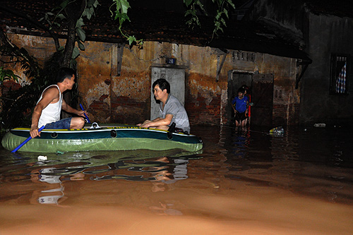 Một v&agrave;i hộ d&acirc;n d&ugrave;ng thuyền, phao để di chuyển v&agrave; vận chuyển đồ đạc về nh&agrave; trong đ&ecirc;m khi nước lũ đang r&uacute;t xuống