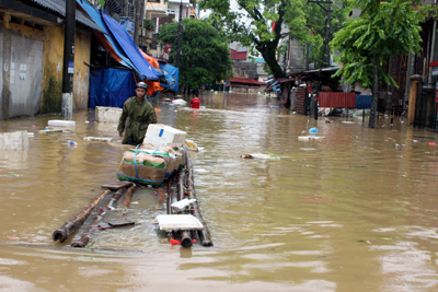 Người d&acirc;n cố gắng tận dụng mọi phương tiện để di dời vật dụng gia đ&igrave;nh trong nước lũ