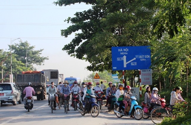 Đi theo từng tốp một rải r&aacute;c b&ecirc;n l&agrave;n đường ngược chiều để rẽ v&agrave;o đường hầm nhỏ tới nơi l&agrave;m việc