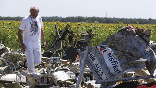 Người bố George Dyczynski mặc chiếc áo phông in hình con gái, đứng trước đống đổ nát của MH17