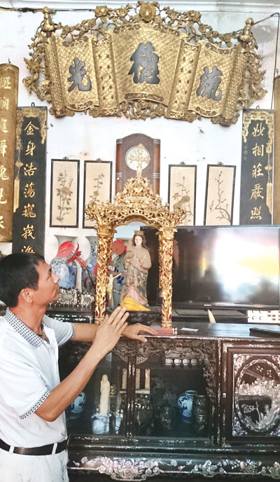 Anh Huy b&ecirc;n chiếc tủ gỗ v&agrave; cuốn thư thiếp v&agrave;ng trị gi&aacute; 300 triệu đồng