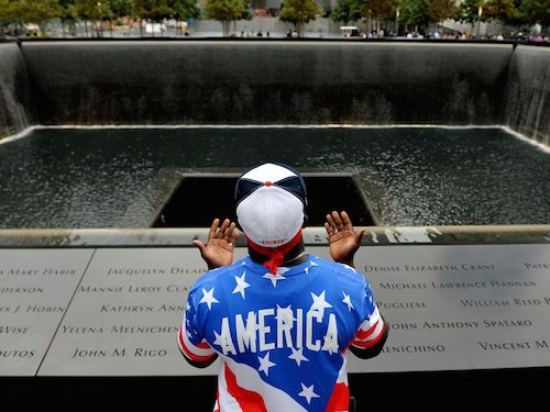 Albert Biatta cầu nguyện trước bức tường có khắc tên người chú đ&atilde; thiệt mạng trong vụ khủng bố
