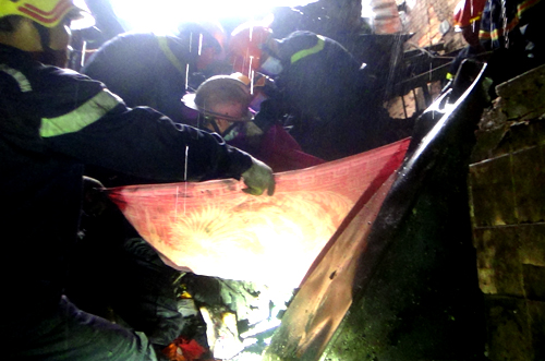  L&iacute;nh cứu hộ d&ugrave;ng chăn quấn nạn nh&acirc;n để đưa ra ngo&agrave;i. Ảnh: C.H