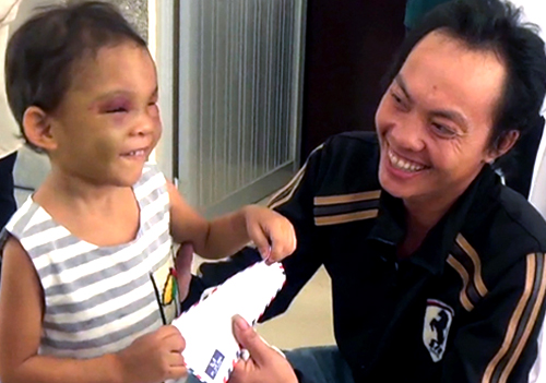 B&eacute; Ng&acirc;n cười đ&ugrave;a trong v&ograve;ng tay cha v&agrave; mọi người (Ảnh: Duy Trần/VnExpress)