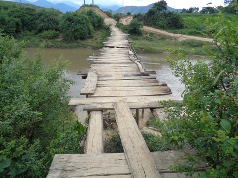 Thầy c&ocirc; v&agrave; học sinh đi qua cầu tạm đến điểm trường