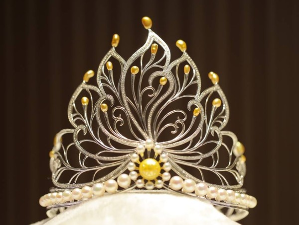 Theo Ban tổ chức, vương miện cao 136 mm, chiều ngang 140 mm, điểm nhấn l&agrave; vi&ecirc;n ngọc trai trống đồng 15 mm m&agrave;u v&agrave;ng qu&yacute; hiếm được đặt ở t&acirc;m. Xung quanh l&agrave; 18 vi&ecirc;n ngọc trai m&agrave;u v&agrave;ng kim c&oacute; h&igrave;nh dạng tự nhi&ecirc;n, 36 vi&ecirc;n ngọc trai biển Akoya m&agrave;u trắng c&ugrave;ng 1.000 vi&ecirc;n kim cương đ&iacute;nh tr&ecirc;n c&aacute;c họa tiết c&aacute;nh sen bằng v&agrave;ng trắng. 