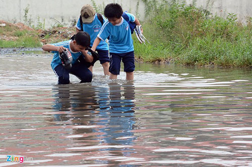 Những học sinh nam ở trường tiểu học L&ecirc; Trọng Tấn kh&ocirc;ng c&ograve;n lựa chọn n&agrave;o kh&aacute;c l&agrave; phải xắn quần lội qua 