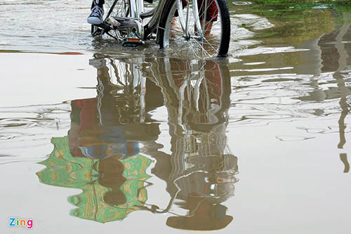 B&agrave; Nguyễn Thị Kim Đồng mỗi ng&agrave;y phải lội qua vũng nước n&agrave;y 4 lần để đưa 2 đứa ch&aacute;u đi học. B&agrave; cho biết, v&igrave; đoạn đường đến trường phải đi qua c&aacute;c hố nước s&acirc;u kh&ocirc;ng an to&agrave;n n&ecirc;n d&ugrave; bận rộn vẫn phải d&agrave;nh thời gian đưa rước c&aacute;c ch&aacute;u.