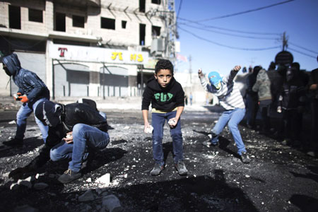 Thanh ni&ecirc;n Palestine n&eacute;m đ&aacute; về ph&iacute;a cảnh s&aacute;t bi&ecirc;n giới Israel trong cuộc đụng độ tại một trạm kiểm so&aacute;t giữa c&aacute;c trại tị nạn Shuafat v&agrave; Jerusalem