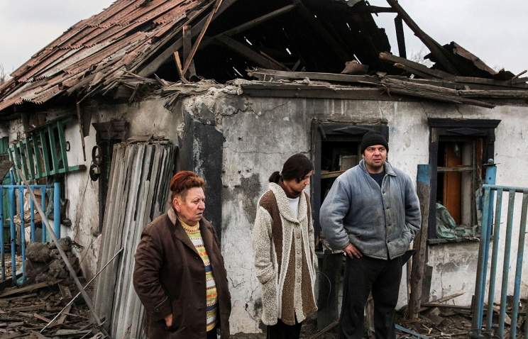 Người d&acirc;n Donetsk, miền Đ&ocirc;ng Ukraine b&ecirc;n ngo&agrave;i ng&ocirc;i nh&agrave; bị ph&aacute; huỷ bởi những cuộc giao tranh giữa qu&acirc;n ch&iacute;nh phủ v&agrave; phe ly khai