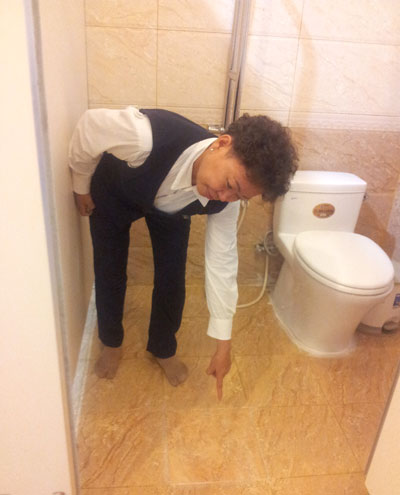 Chị Yến chỉ vị tr&iacute; nh&agrave; VSCC đ&atilde; được đ&agrave;o l&ecirc;n để sửa chữa nhưng đến nay vẫn hỏng