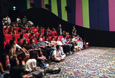 Nhiều kh&aacute;n giả ngồi bệt xuống đất xem phim