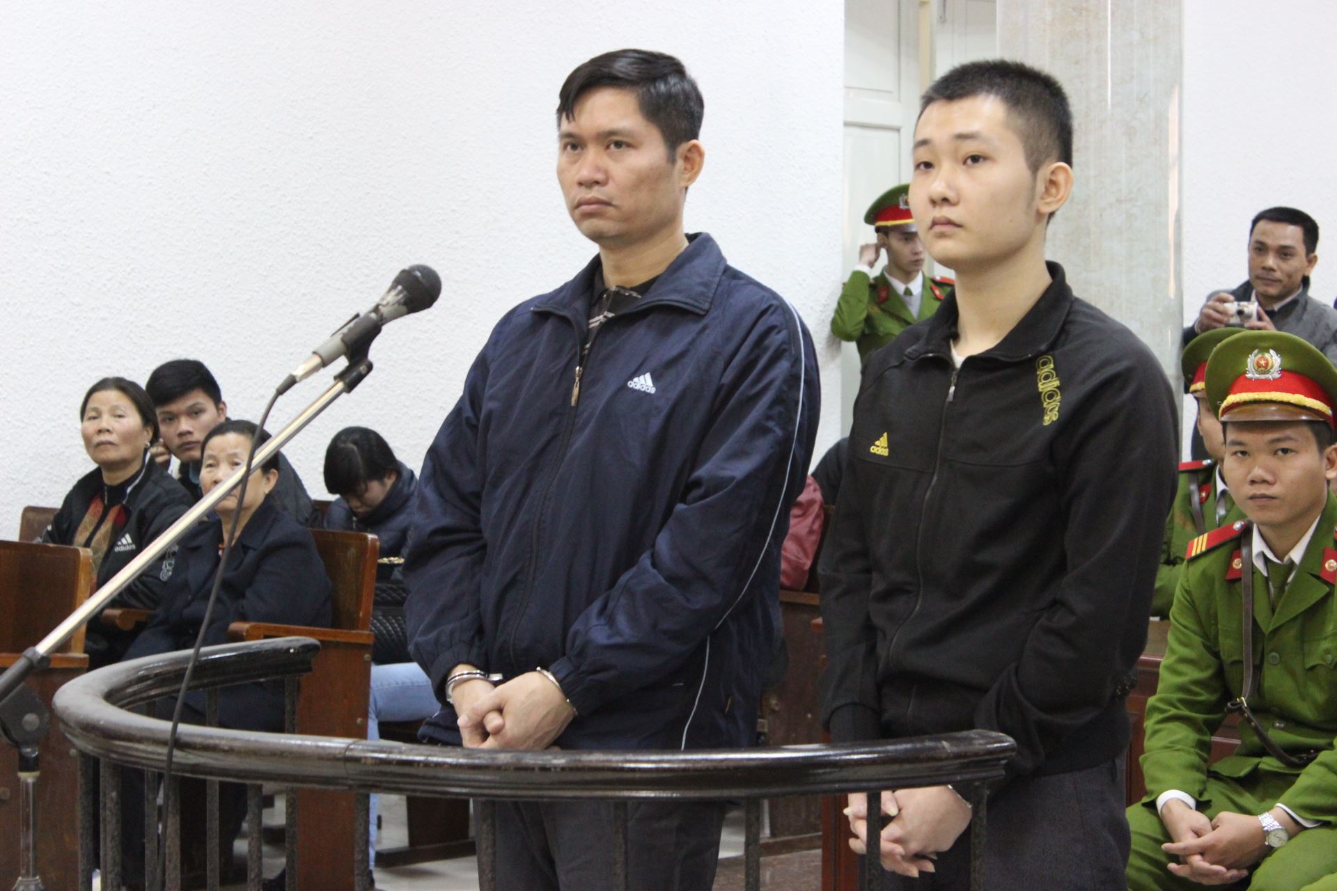 Hai bị c&aacute;o Nguyễn Mạnh Tường v&agrave; Đ&agrave;o Quang Kh&aacute;nh lặng lẽ đứng trước v&agrave;nh m&oacute;ng ngựa để nghe kết luận của VKS