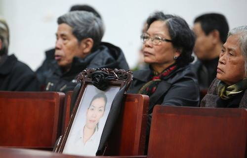 Gia đ&igrave;nh mang di ảnh chị Huyền tới phi&ecirc;n t&ograve;a.