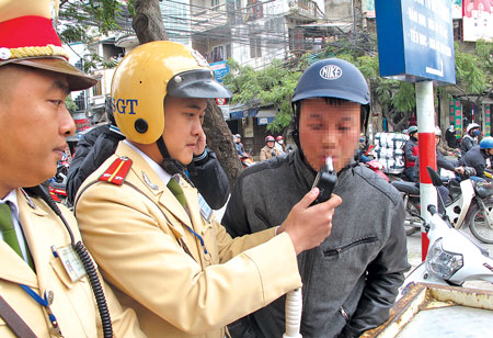 Đội CSGT số 4 (thuộc Ph&ograve;ng CSGT - C&ocirc;ng an TP H&agrave; Nội) kiểm tra nồng độ cồn một người tham gia giao th&ocirc;ng tr&ecirc;n phố Kim Ngưu, quận Hai B&agrave; Trưng, H&agrave; Nội